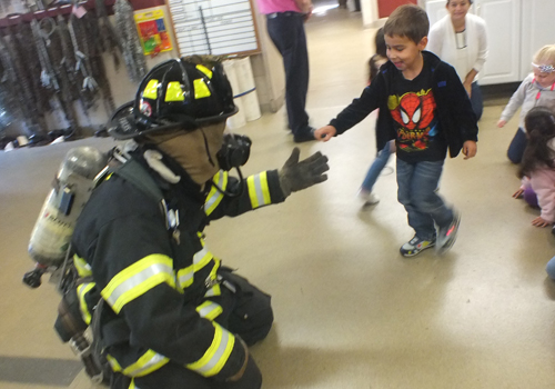 Preschooler giving the fireman a high five