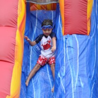 Register before April 1st to receive our early bird discount! Summer Fun boy going down a slide