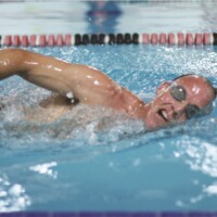 Adult male swimming laps in indoor pool